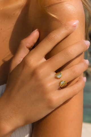 Paloma Gold Ring, worn on a finger showing the open design with two crystals