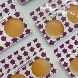 Silicone Nipple Covers in beige, round covers shown in purple flower-patterned packaging