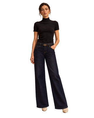 The Bri Short Sleeve Sweater – in black, front view on model, worn with dark wide-leg jeans